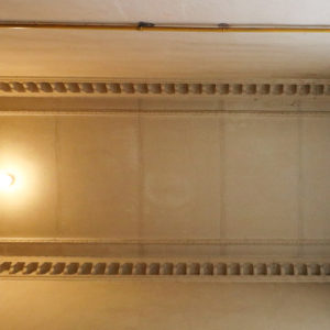 Sufit na ostatnim piętrze frontowej klatki schodowej. Według mnie prawdopodobne jest, że pod farbą są zakryte dawne polichromie (spod farby przebijają trzy okrągłe kształty)